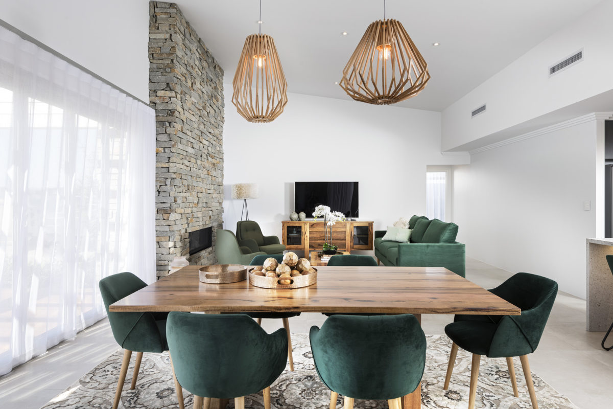 Stylish open-plan living area with stone feature wall and dining space, part of modern corner block house designs with seamless layout flow.