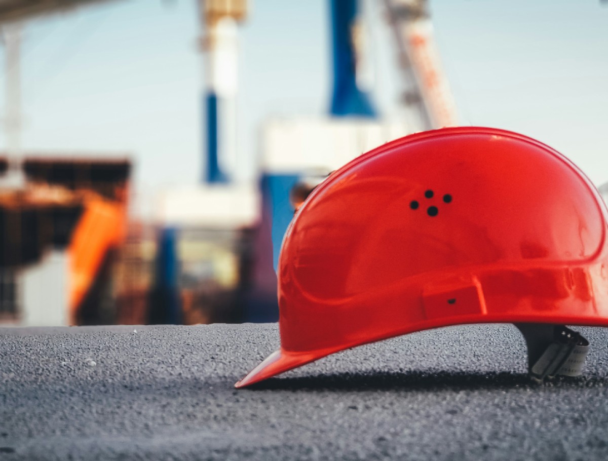 Construction stages WA Red construction helmet resting on a home building site for a Perth home currently going through the construction stages of home building.